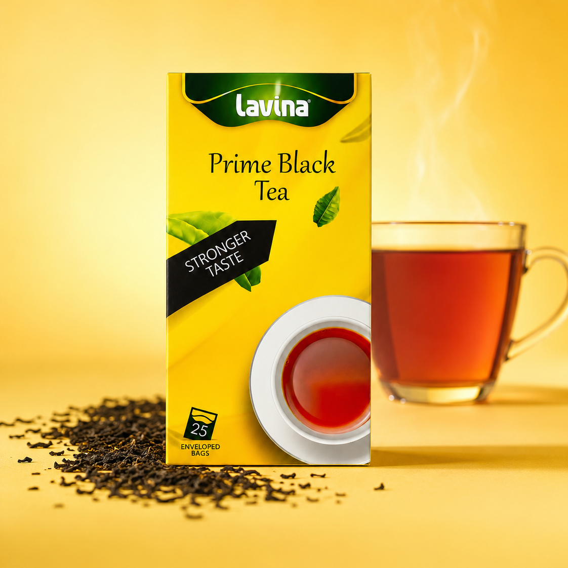 A box of Lavina Prime Black Tea stands on a yellow studio background with scattered tea leaves in front and a steaming glass cup of tea to the right.